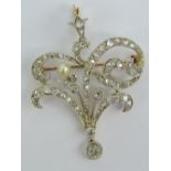 A delightful Edwardian diamond and pearl pendant/brooch of floral design complete with original