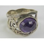 A silver and amethyst ring, the central oval faceted amethyst cabachon being approx 11 x 9mm,