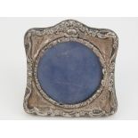 A miniature HM silver photograph frame having floral decoration, velvet covered easel back,