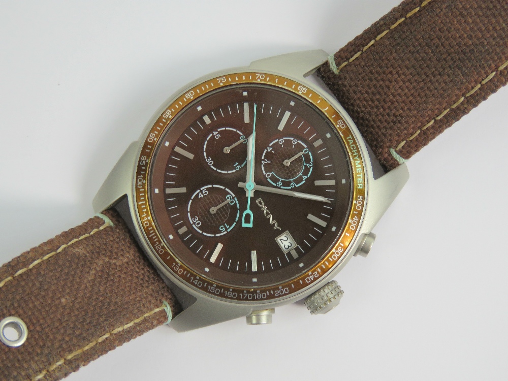 A DKNY stainless steel gents wristwatch having brown dial with three subsidiary dials and date