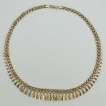 A 9ct gold articulated necklace having three-row panel chain with graduated 'tassles' upon,