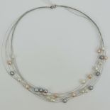 A silver and pearl necklace having eight silver wires of peach, white and black 'floating' pearls,