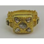 A heavy Etruscan Revival yellow metal ring set with seven rose cut diamonds,