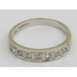 An 18ct white gold and diamond ring having seven round cut illusion set diamonds, hallmarked 750,