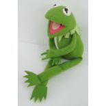 A vintage Muppets Kermit the Frog felt toy having velcro pads to hands and feet, no labels,
