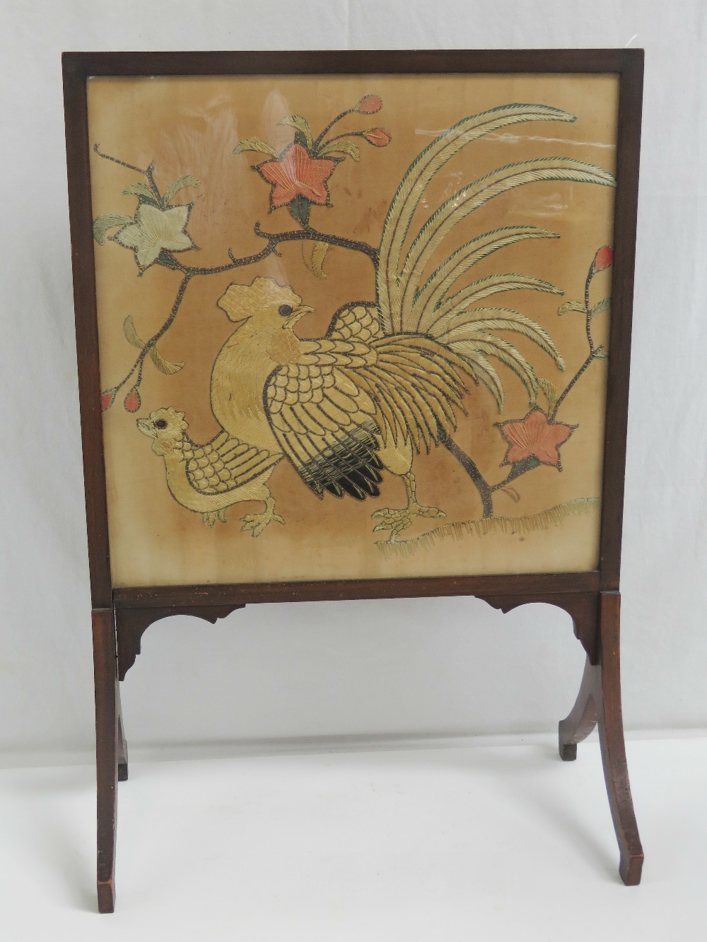 A vintage fire screen having embroidery