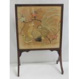 A vintage fire screen having embroidery