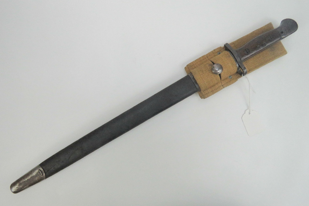 A WWI British Lee Enfield rifle 1907 pattern bayonet, dated 1916 in scabbard with canvas hanger.