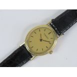 A 9ct gold ladies Tissot wristwatch having yellow metal hands and batons to the oval dial,