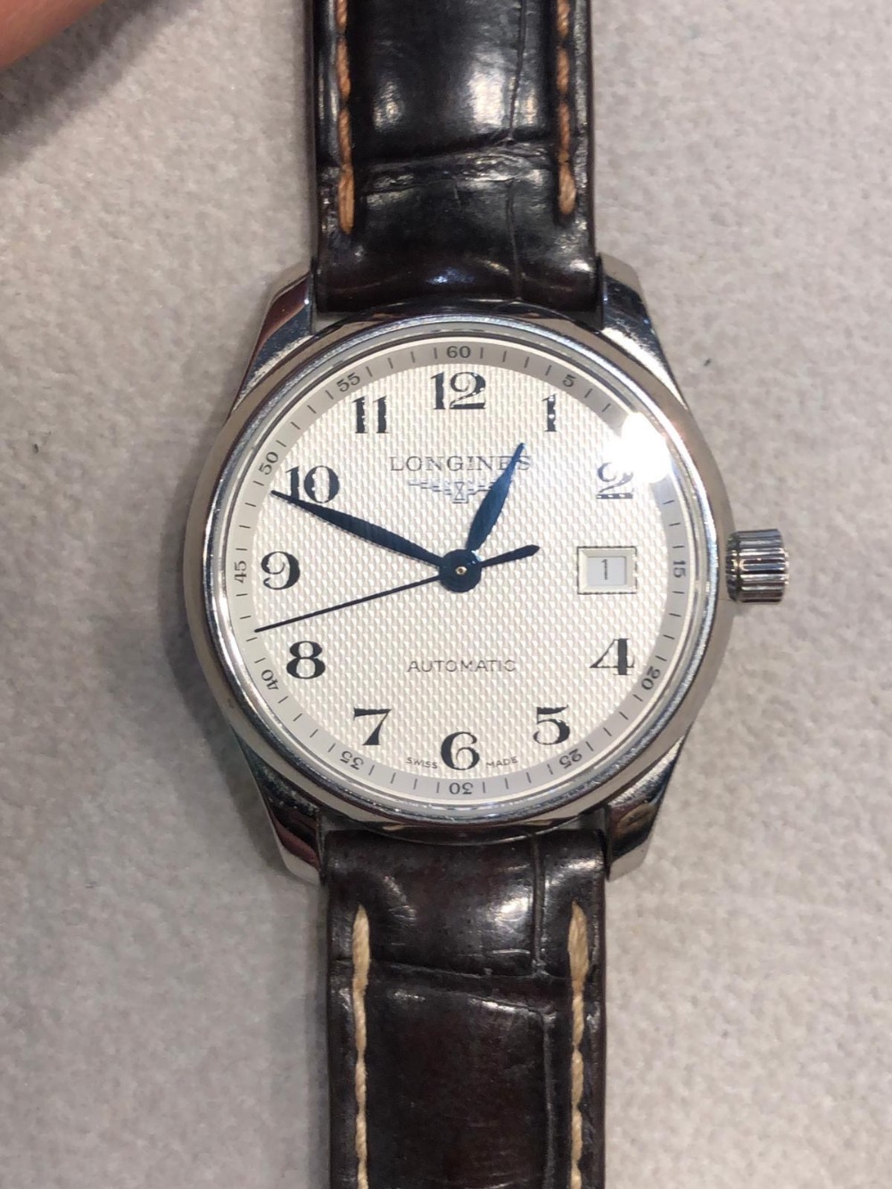 A Longines automatic wrist watch having engine turned dial, Arabic numerals and date aperture,