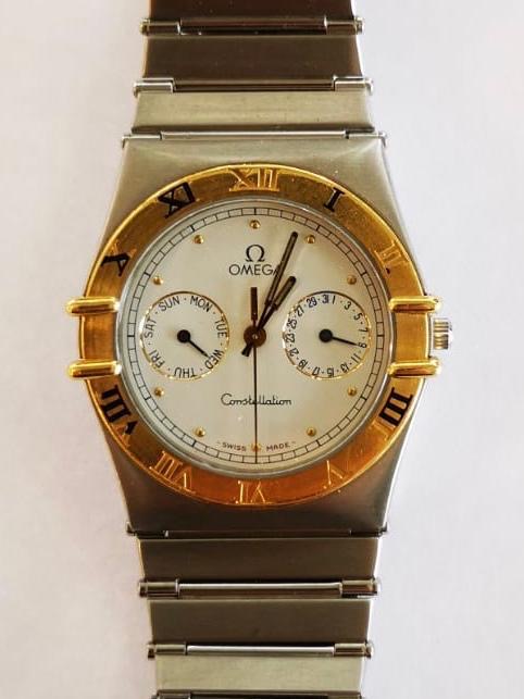 An Omega Constellation bi-colour wrist watch having yellow metal chaptering with Roman numerals