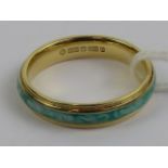 An 18ct gold ring with central green and white band, hallmarked 750, M-N, 3.6g.