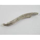 An 18ct white gold and diamond brooch in the form of two graduated sweeping waves encrusted with