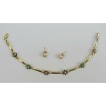 A 14ct gold bracelet having six floral gem set panels (one stone deficient),