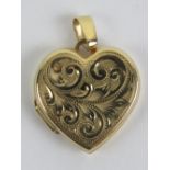 A 9ct gold heart shaped locket having scrolling vine engraving to front, 1.