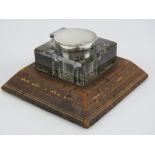 An Asprey desk inkwell having HM silver collar and lid with embossed tan leather base,