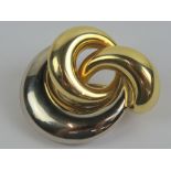 An 18ct white and yellow gold brooch having abstract swirl design and hallmarked 750, 3.5 x 2.