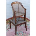 A 19th century bergere metamorphic childs chair, raised over square shaped base,