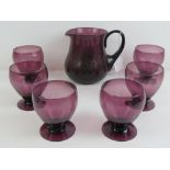 An amethyst glass water jug and six matching tumblers.