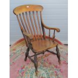 A late Victorian elm seated lathe back Windsor open arm chair.