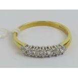 An 18ct gold seven stone diamond ring, the round cut brilliant diamonds totalling 0.