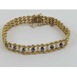 A 14ct gold sapphire and diamond bracelet comprising three rows of rope twist chain with an open