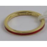 An 18ct gold ring having central red enamel band, hallmarked 750, size L, 1.9g.