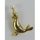 An 18ct gold Sealion brooch having pearl 'ball' balanced on its nose, stamped 750, 3.7cm high, 8g.