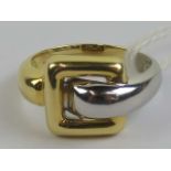 An 18ct white and yellow gold buckle ring, hallmarked 750, size M-N, 5.8g.