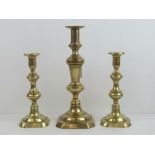 A pair of brass candlesticks with pushers standing 22cm high.
