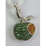 An 18ct white gold charm in the form of an apple set with green garnets and yellow sapphires,