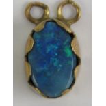 An oval doublet opal cabachon in yellow metal pendant mount, the cabachon approx 10 x 6.5 x 3mm.