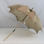 A 19th century ladies silk parasol having profusely carved and hinged ivory handle,