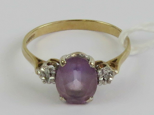 A 9ct gold amethyst and diamond ring, the central oval cut amethyst measuring approx 8.8 x 6.8 x 4.