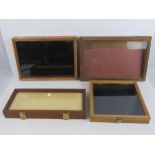 Four wooden display cases having glazed lids. Various sizes.