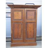 A large 19th century pine two door hall cupboard profusely carved and decorated throughout,