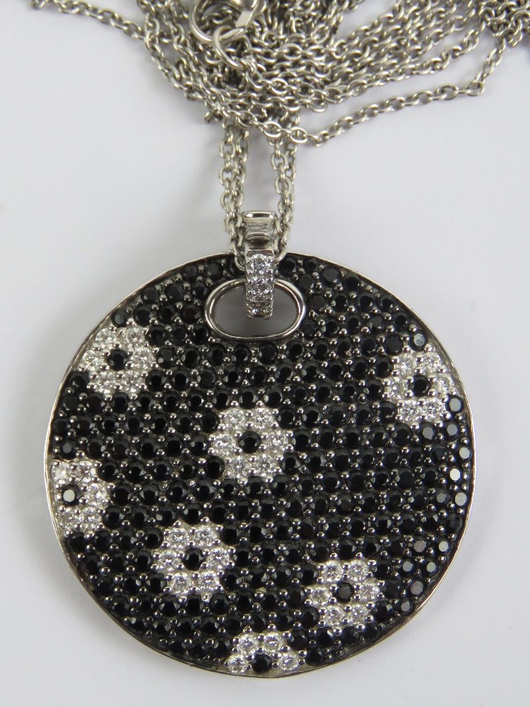 An 18ct gold pendant set with black sapphires and diamonds in a floral pattern, 3cm dia,