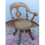 A 1930s circular cane seated swivel office chair in oak raised over four outswept legs, a/f.