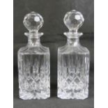 A pair of cut glass square shaped decanters each with stopper.