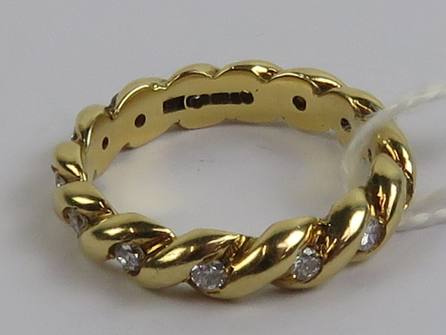 An 18ct gold and diamond eternity ring having rope twist pattern to band, approx total 0.