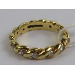 An 18ct gold and diamond eternity ring having rope twist pattern to band, approx total 0.