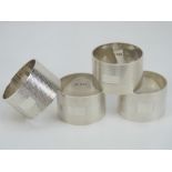 A set of four HM silver napkin rings having engine turned pattern upon with blank cartouche,