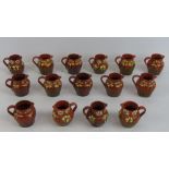 Fifteen hand painted Devon ware type sparrows beak jugs, each standing 8cm tall.