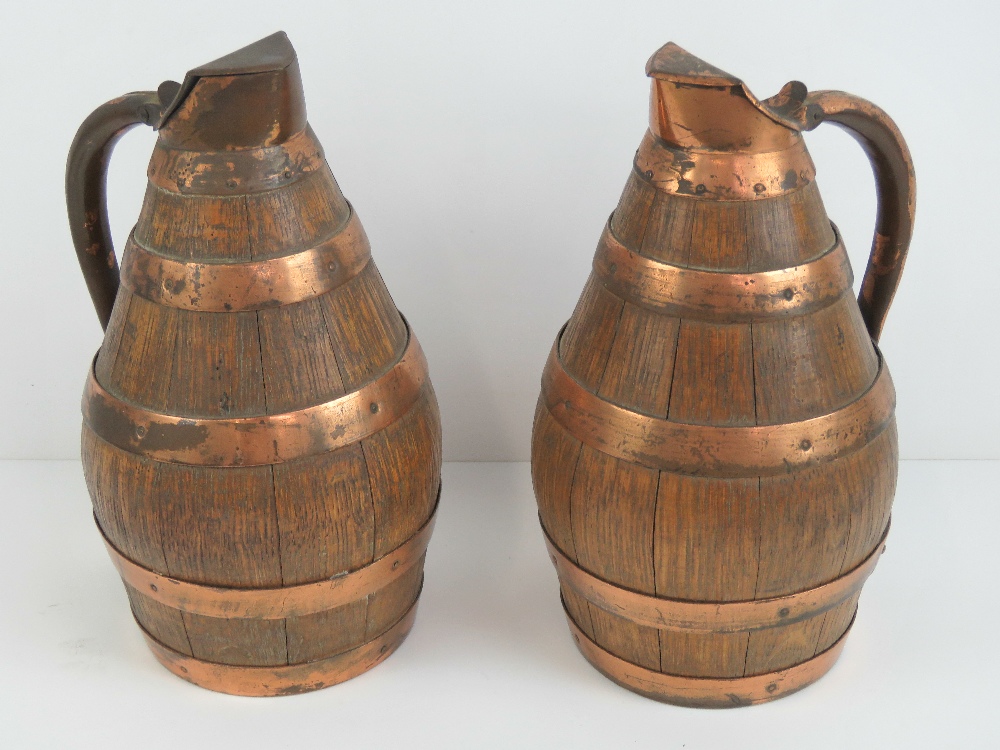 A pair of coopered oak and copper banded lidded jugs, each standing 28cm high.