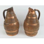 A pair of coopered oak and copper banded lidded jugs, each standing 28cm high.