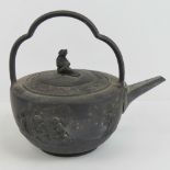 A 19th century Wedgwood black basalt teapot and cover bearing classical figures in relief upon,