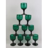 A set of ten green glass footed wine glasses.