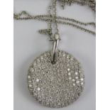 An 18ct white gold wave disc pendant encrusted with round cut diamonds, approx 2.