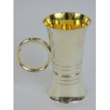 A HM silver double ended spirit measure having loop handle and gilded interior,