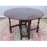 An early 20th century oak oval drop leaf gate leg table, 96 x 120cm extended.